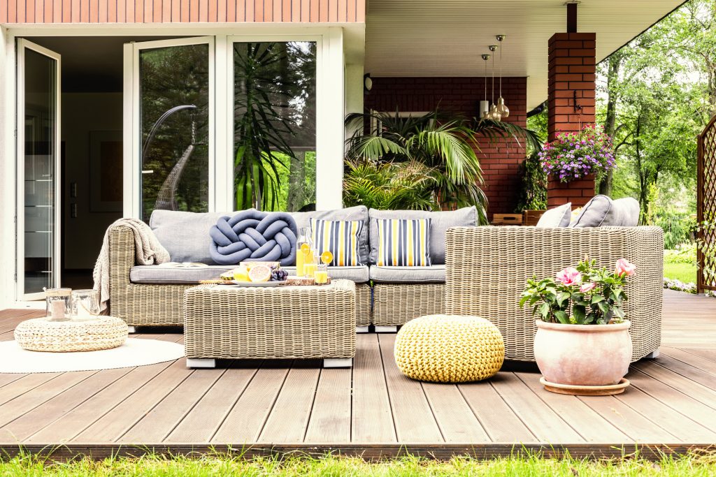 Outdoor patio seating area with big sofa and table.